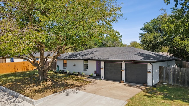 ranch-style house featuring a garage and a front lawn