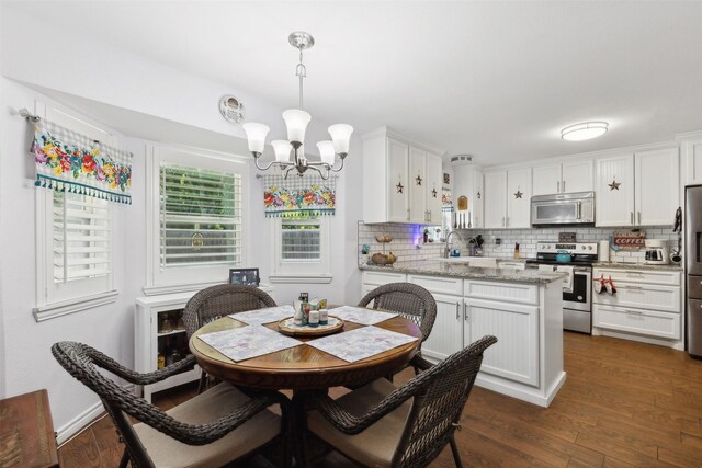 dining area featuring sink, dark hardwood / wood-style flooring, and an inviting chandelier