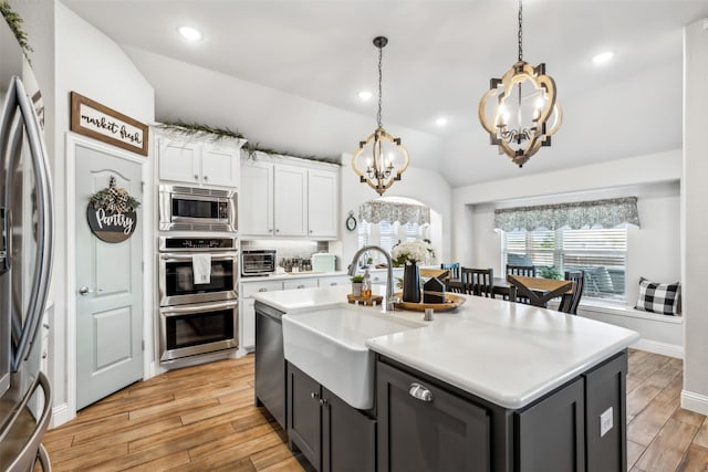 kitchen featuring custom range hood, ceiling fan, stainless steel appliances, light hardwood / wood-style floors, and white cabinets