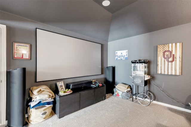 carpeted home theater room featuring vaulted ceiling