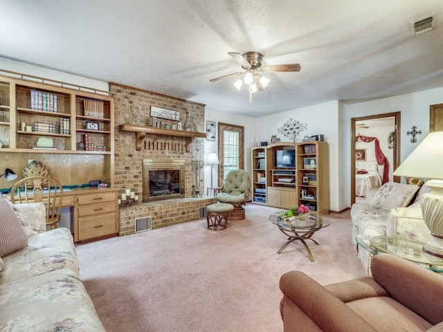 living room with light colored carpet, a textured ceiling, a brick fireplace, and ceiling fan