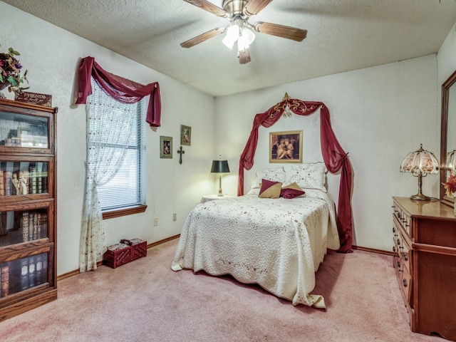 bedroom featuring ceiling fan, a textured ceiling, and light carpet