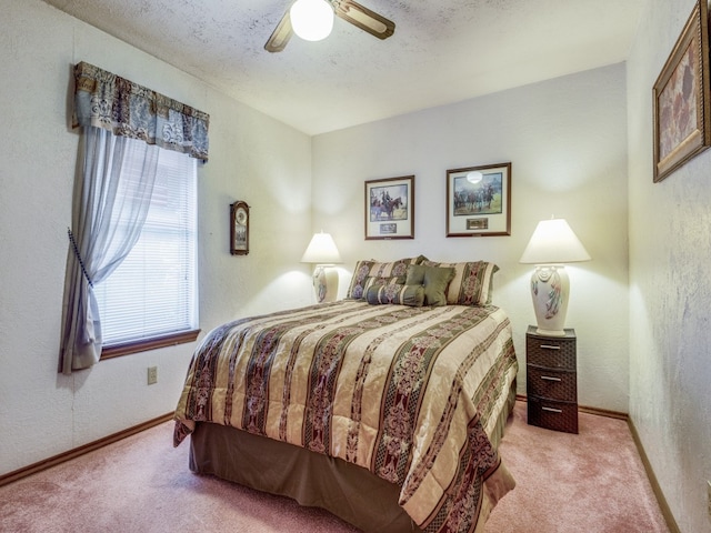 carpeted bedroom with ceiling fan and a textured ceiling