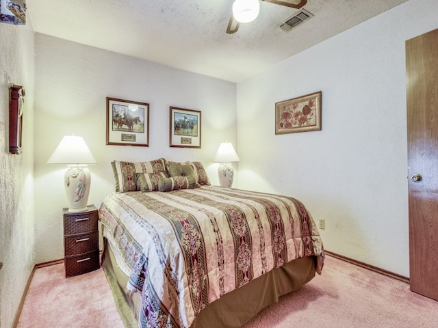 carpeted bedroom with ceiling fan and a textured ceiling