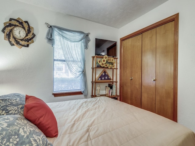 bedroom with a textured ceiling and a closet