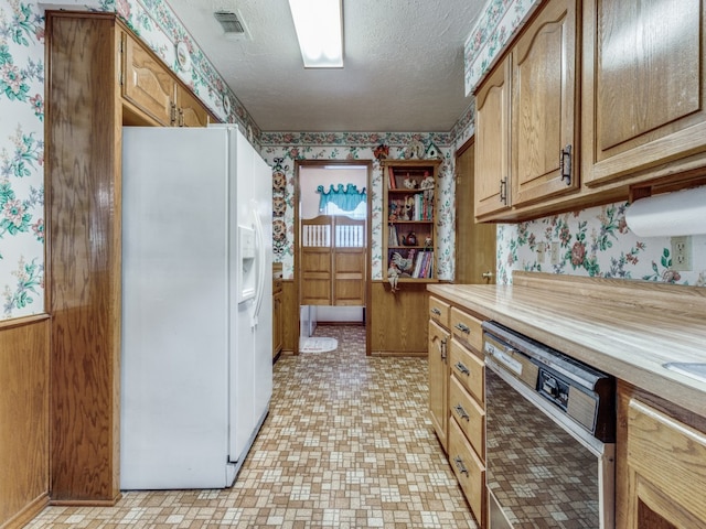 kitchen featuring light tile patterned floors, dishwasher, a textured ceiling, and white refrigerator with ice dispenser