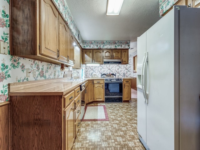 kitchen with black / electric stove, white refrigerator with ice dispenser, sink, a textured ceiling, and light tile patterned flooring