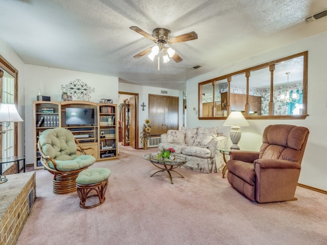 living room featuring ceiling fan, carpet, and a textured ceiling