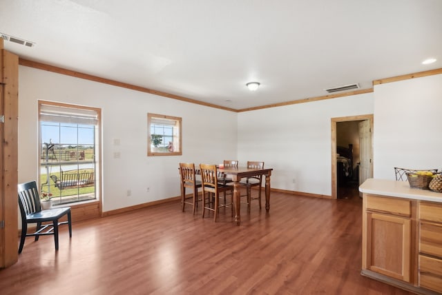 dining space featuring crown molding and hardwood / wood-style floors