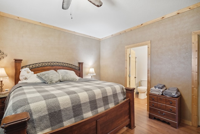 bedroom featuring light hardwood / wood-style floors, ceiling fan, and ensuite bath