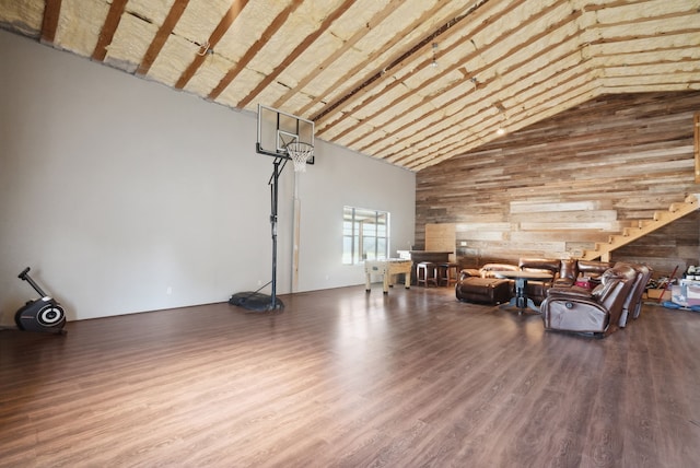 misc room with high vaulted ceiling, wooden walls, and hardwood / wood-style floors