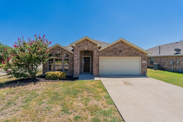 view of front of house with a garage, concrete driveway, a front yard, central AC, and brick siding