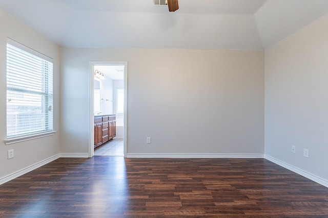 empty room with ceiling fan, vaulted ceiling, and wood-type flooring