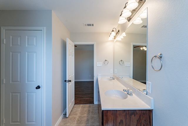 bathroom featuring hardwood / wood-style flooring, double sink vanity, and ceiling fan