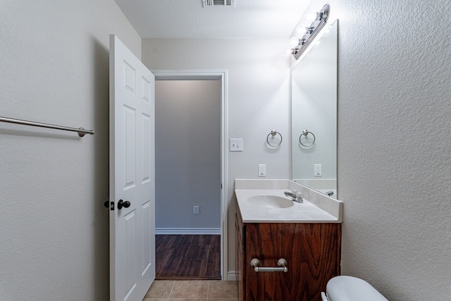 bathroom with tile patterned flooring, toilet, and vanity