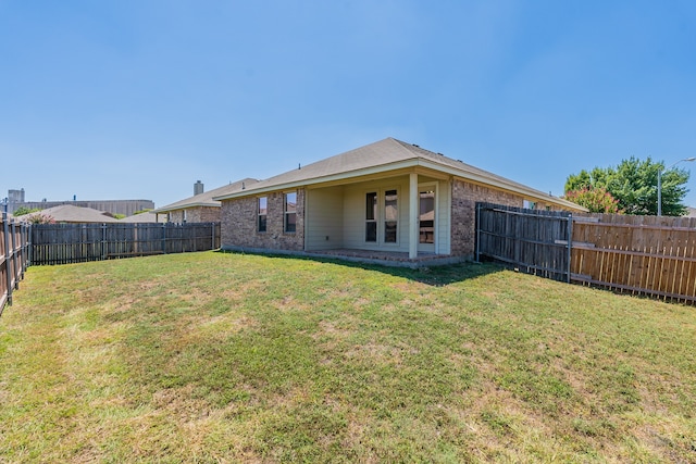 rear view of house featuring a lawn