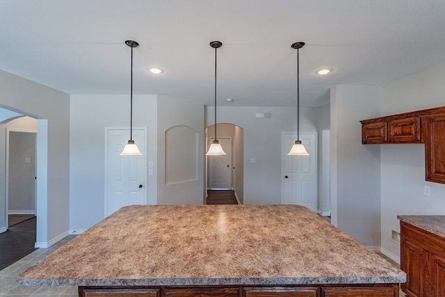 kitchen featuring a center island, wood-type flooring, and hanging light fixtures