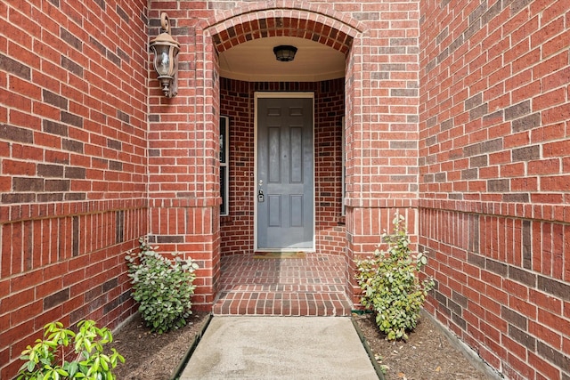 doorway to property with brick siding