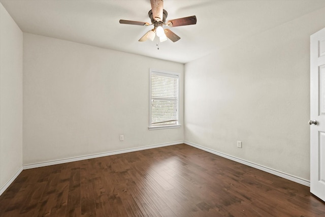 empty room featuring dark wood-style floors, baseboards, and a ceiling fan