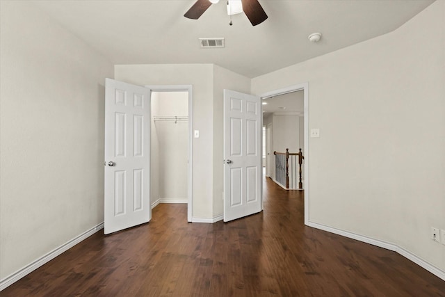 unfurnished bedroom featuring ceiling fan, baseboards, visible vents, and dark wood finished floors