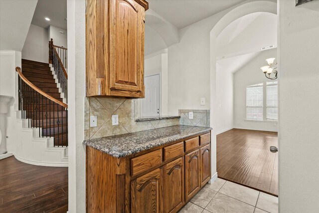 kitchen featuring a notable chandelier, tasteful backsplash, and light hardwood / wood-style flooring