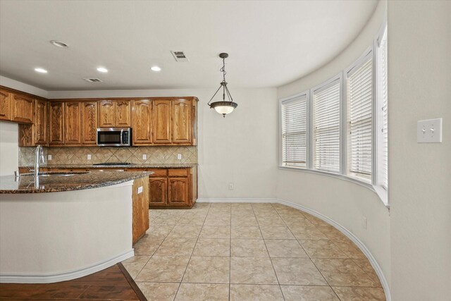 kitchen featuring light tile patterned flooring, sink, decorative backsplash, stainless steel appliances, and pendant lighting