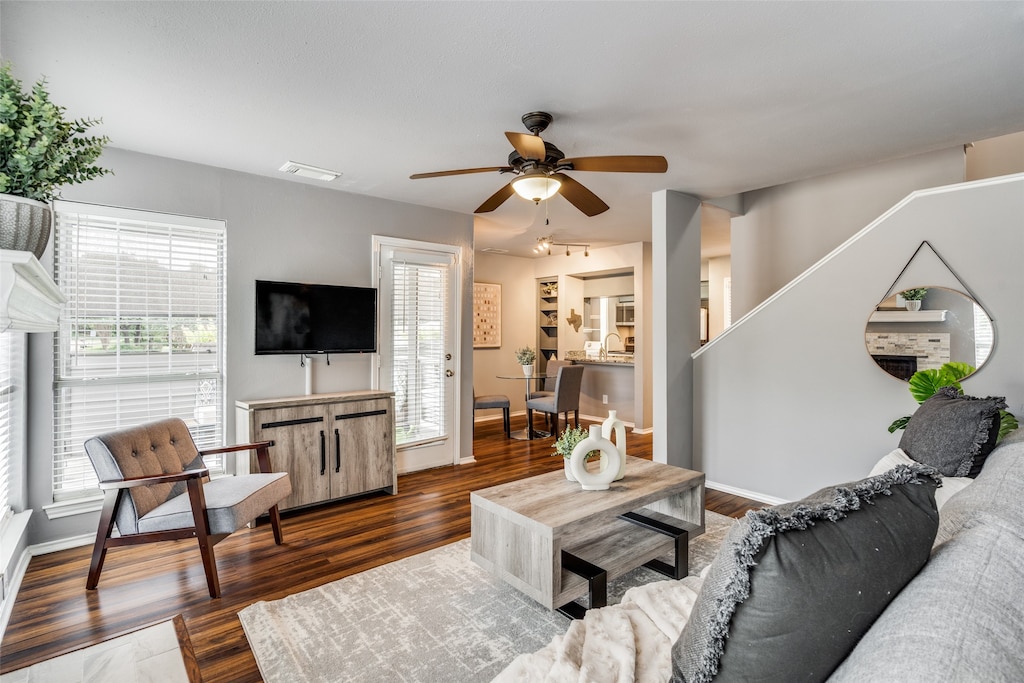 living room with ceiling fan, plenty of natural light, dark wood-type flooring, and sink