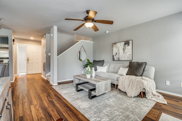 living room with ceiling fan and dark wood-type flooring