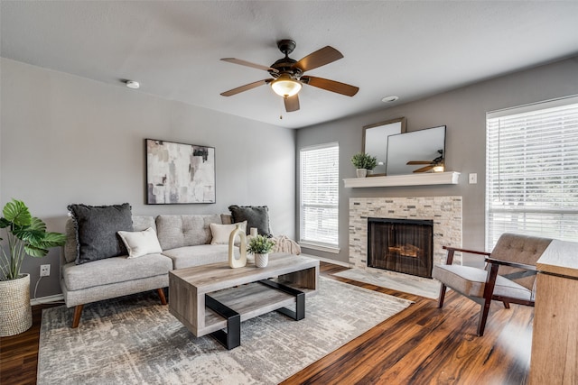 living room with wood-type flooring, a fireplace, and ceiling fan