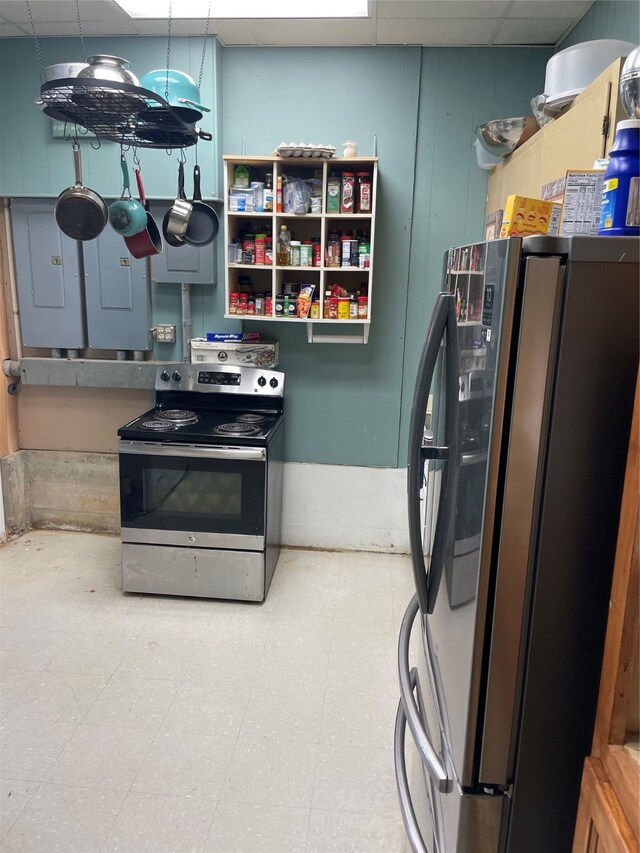 kitchen with electric panel, stainless steel appliances, and a drop ceiling