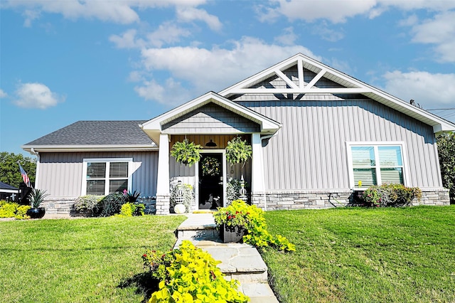 view of front of property featuring a shingled roof, board and batten siding, and a front lawn