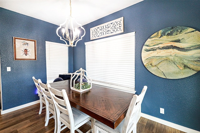 dining area featuring a notable chandelier, baseboards, wood finished floors, and a textured wall