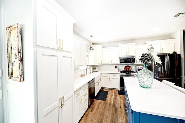 kitchen with stainless steel appliances, light countertops, visible vents, and decorative backsplash