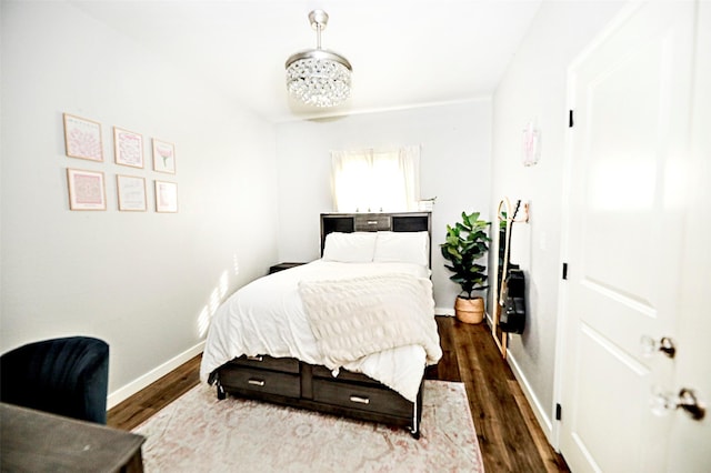 bedroom featuring an inviting chandelier, baseboards, and dark wood-style flooring