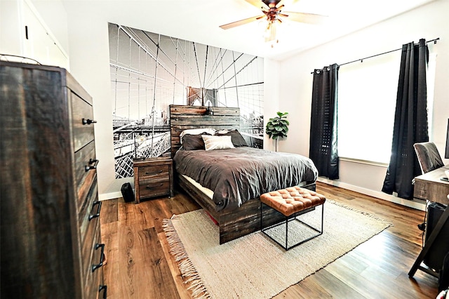 bedroom featuring ceiling fan, baseboards, and wood finished floors