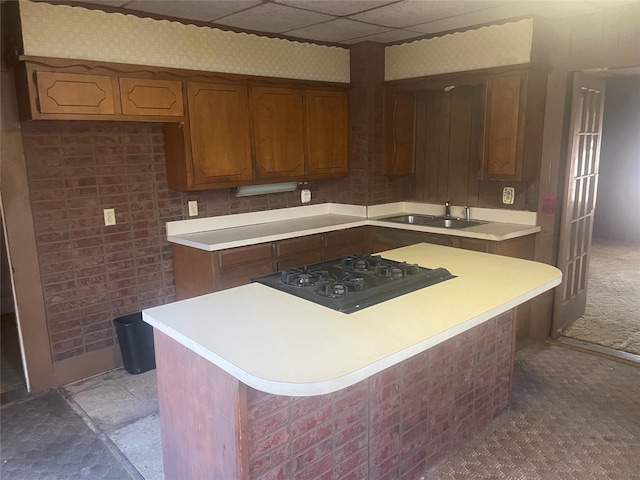 kitchen with a kitchen island, a drop ceiling, black gas stovetop, and sink