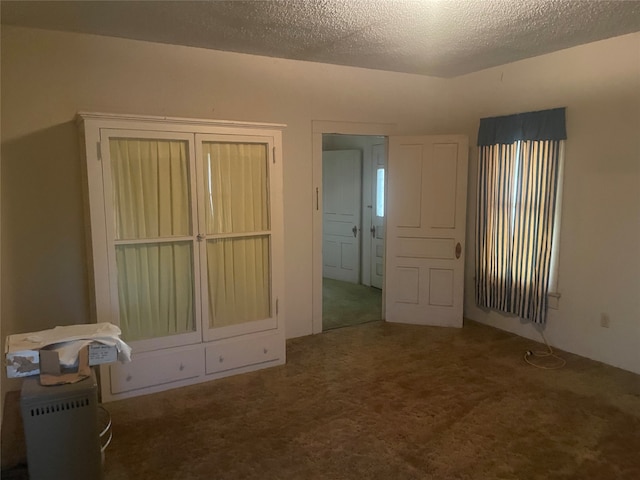 unfurnished bedroom featuring a textured ceiling and carpet floors