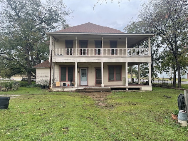 view of front of house with a balcony and a front yard