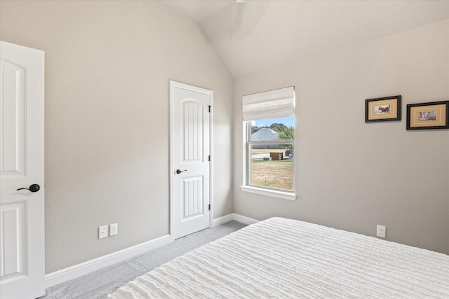 bedroom with baseboards, lofted ceiling, and carpet flooring