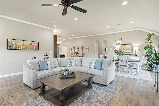 living area with arched walkways, visible vents, and light wood-style floors