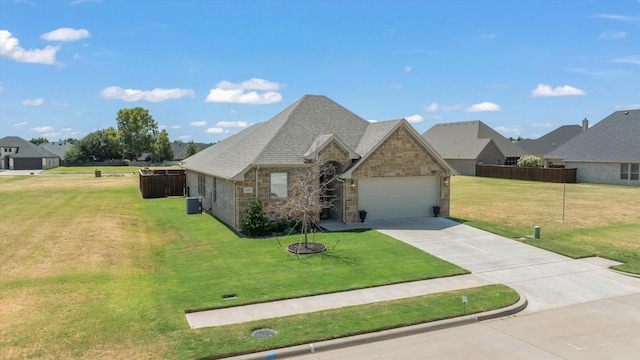 view of front of property featuring a front yard, central AC, a garage, stone siding, and driveway