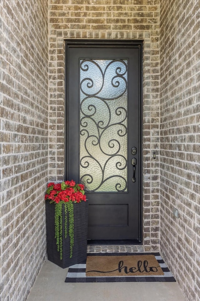 view of exterior entry featuring brick siding