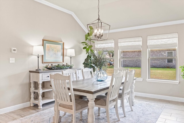 dining room featuring a wealth of natural light, light wood-style floors, crown molding, and vaulted ceiling