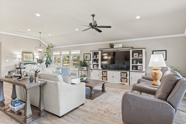 living room featuring ceiling fan with notable chandelier, lofted ceiling, light wood-style floors, and ornamental molding