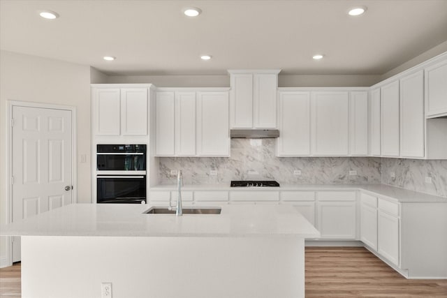 kitchen featuring white cabinetry, sink, and light hardwood / wood-style flooring