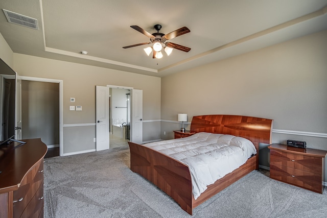 carpeted bedroom featuring ceiling fan and a tray ceiling