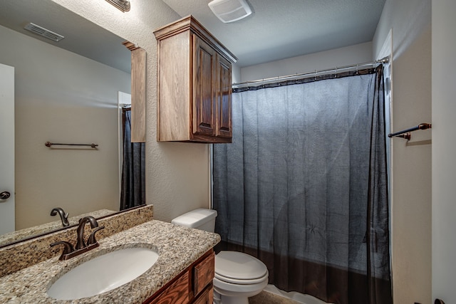 bathroom featuring a textured ceiling, vanity, and toilet