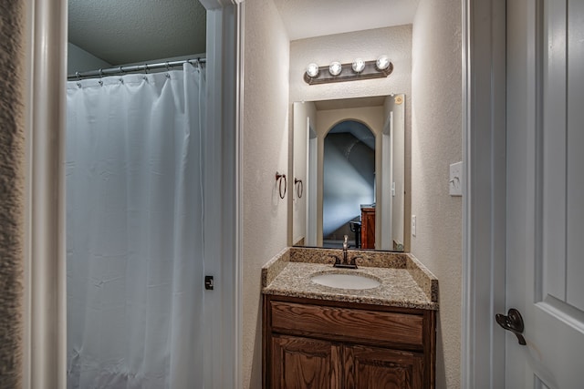 bathroom featuring a textured ceiling and vanity