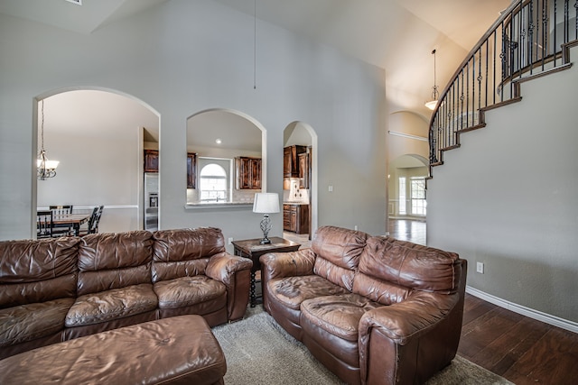 living room featuring dark hardwood / wood-style floors, high vaulted ceiling, and a chandelier