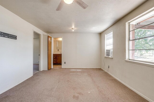 unfurnished room with cooling unit, light carpet, ceiling fan, and a textured ceiling